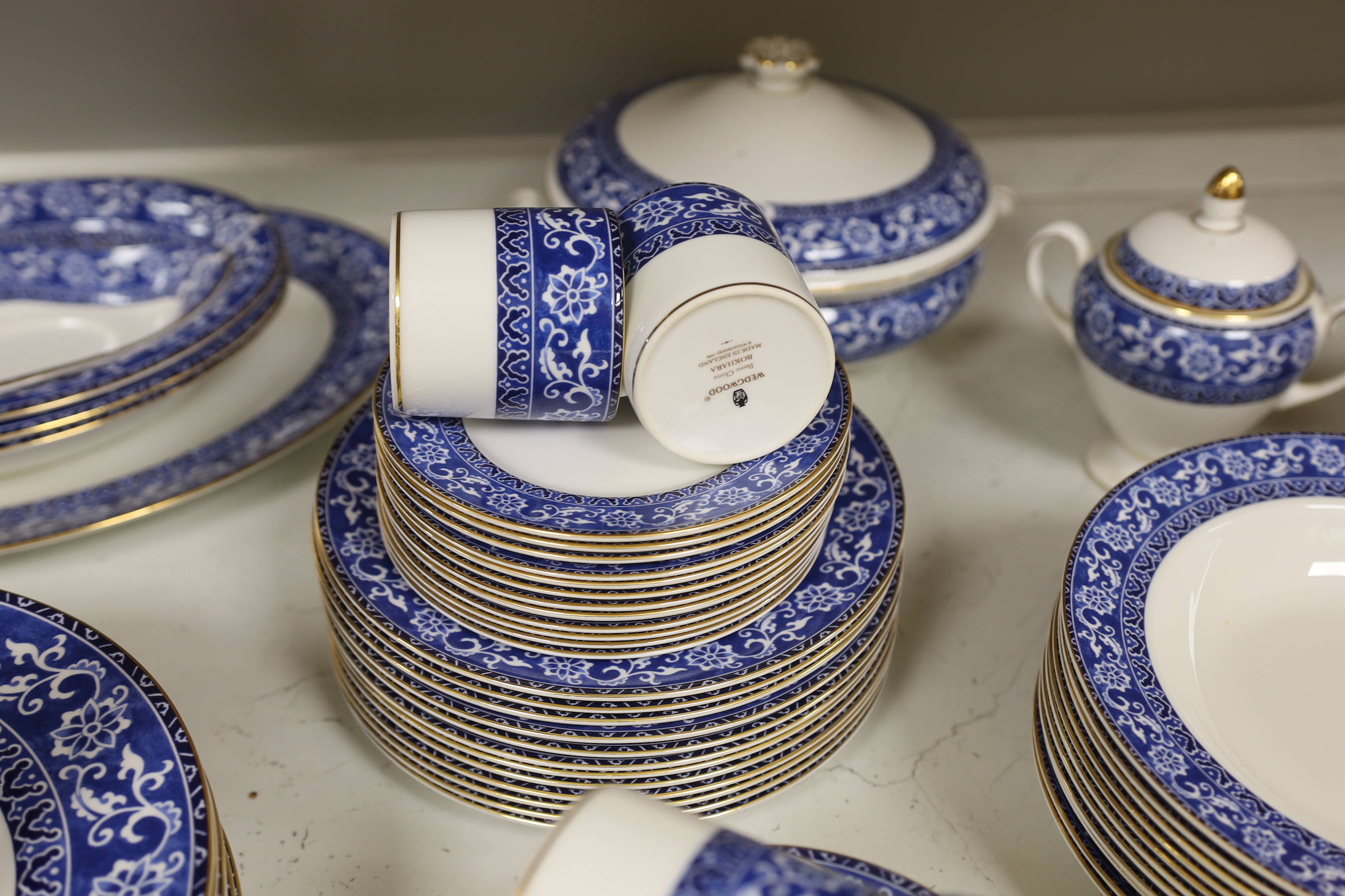 A Wedgwood Bokhara pattern 55 piece part dinner service, including a lidded vegetable tureen, a lidded sugar bowl, a cream jug, 12 dinner plates, 12 side plates, 12 dessert plates, 11 soup bowls, 3 pudding bowls and 2 ov